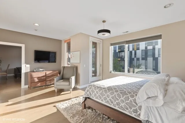 a bedroom with a large bed and a flat screen tv