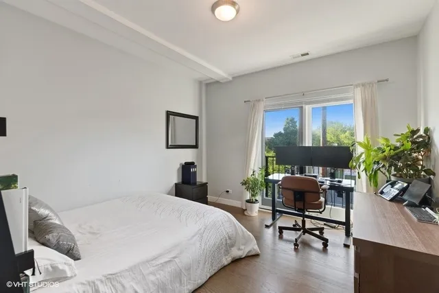 a bedroom with a bed a table chair and a window