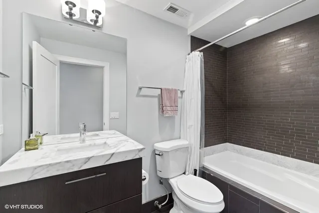 a bathroom with a sink a toilet a mirror and bathtub