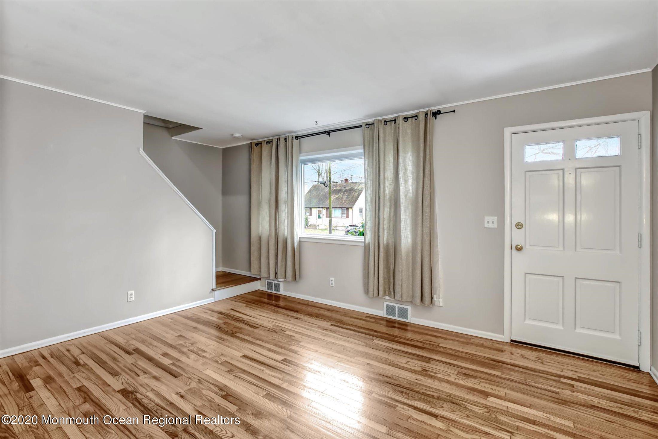515 Couse Road Neptune Township, NJ 07753 - Photo 5 of 26 a view of an empty room with wooden floor and a window