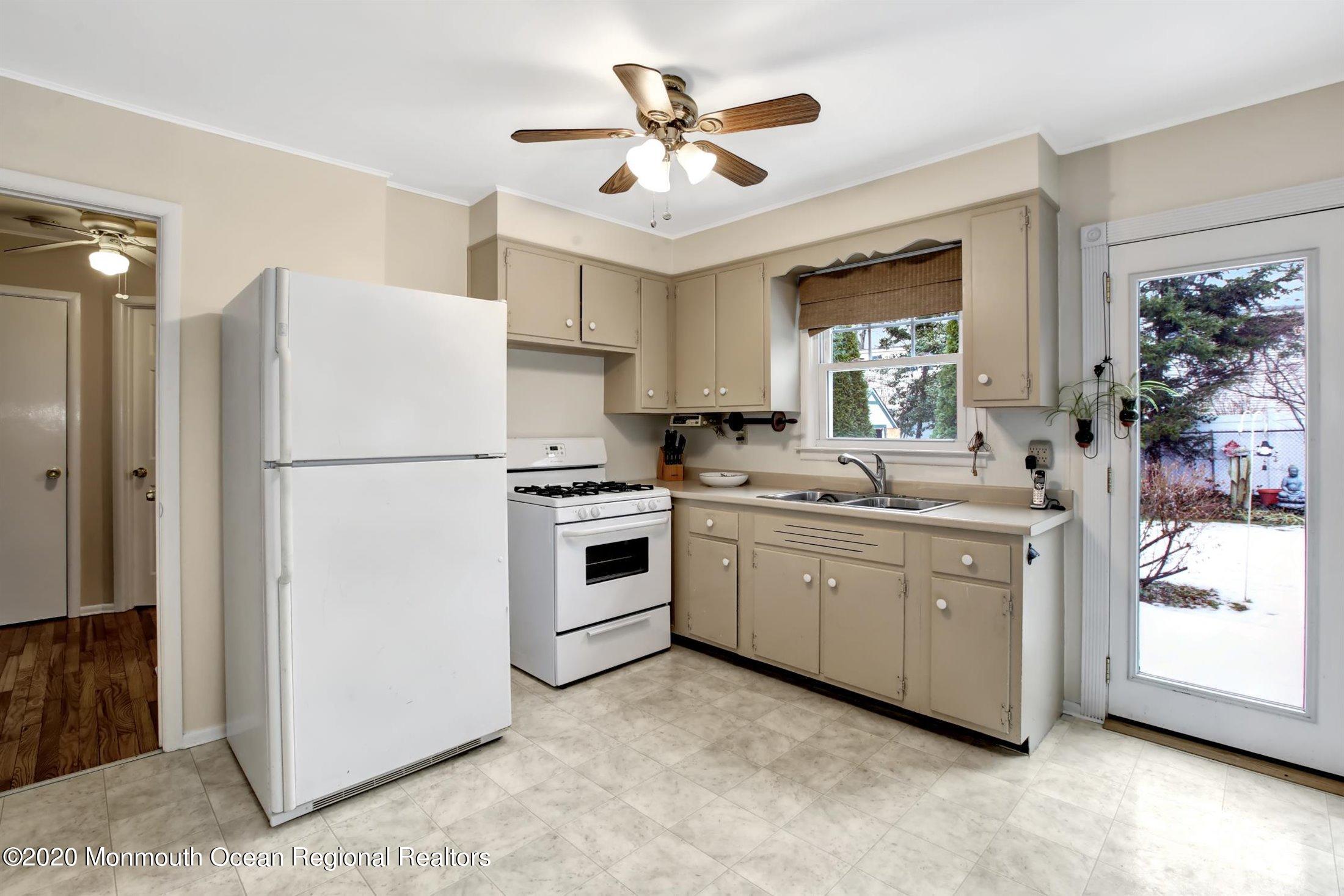 515 Couse Road Neptune Township, NJ 07753 - Photo 8 of 26 a kitchen with white cabinets and white appliances
