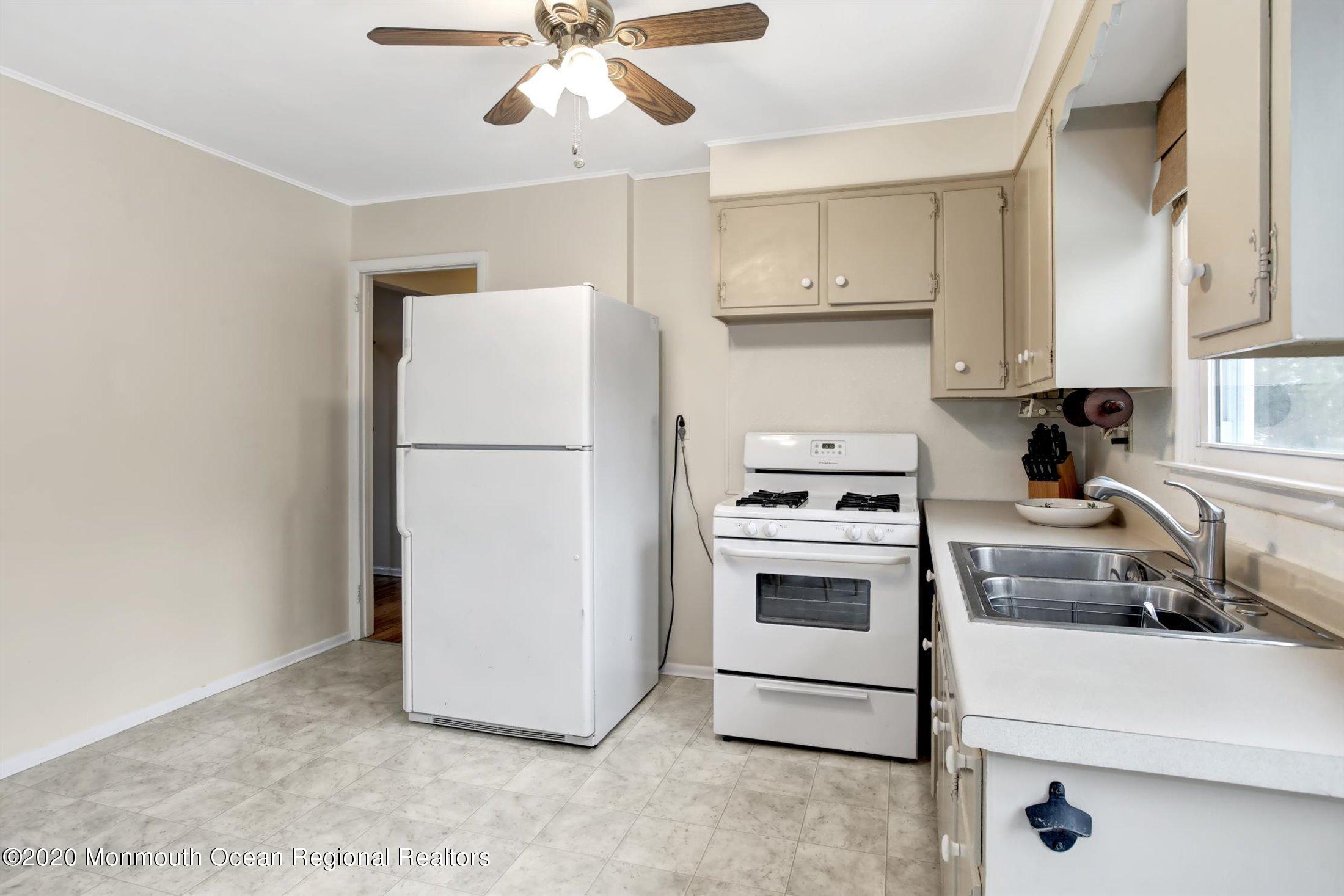 515 Couse Road Neptune Township, NJ 07753 - Photo 10 of 26 a kitchen with a refrigerator and white cabinets
