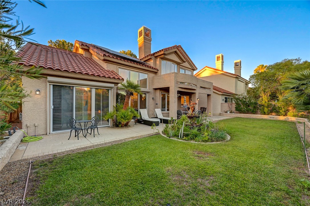 7995 Rio Rico Drive Las Vegas, NV 89113 - Photo 42 of 92 A private yard with a tiled patio and garden beds offers serene outdoor living.