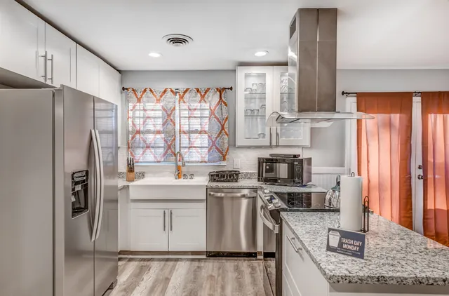 a kitchen with stainless steel appliances granite countertop a refrigerator stove and sink