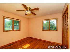 238 Gouges Branch Road Leicester, NC 28748 - Photo 14 of 23 a view of an empty room with a window and wooden floor