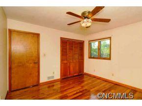 238 Gouges Branch Road Leicester, NC 28748 - Photo 16 of 23 a view of an empty room with wooden floor and a ceiling fan