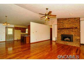 238 Gouges Branch Road Leicester, NC 28748 - Photo 3 of 23 a view of empty room with wooden floor and fireplace