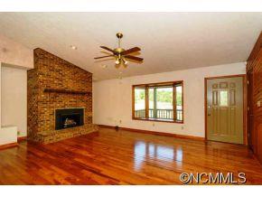 238 Gouges Branch Road Leicester, NC 28748 - Photo 4 of 23 a view of an empty room with a fireplace and wooden floor