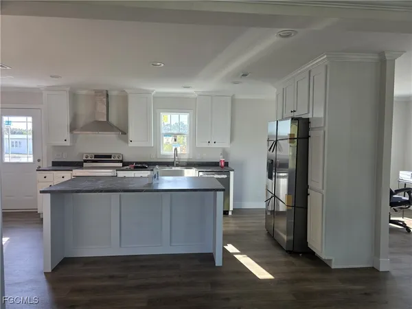 a kitchen with stainless steel appliances granite countertop a refrigerator a stove and a sink