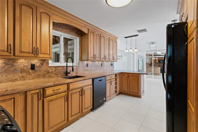 a kitchen with stainless steel appliances granite countertop a refrigerator and a stove top oven