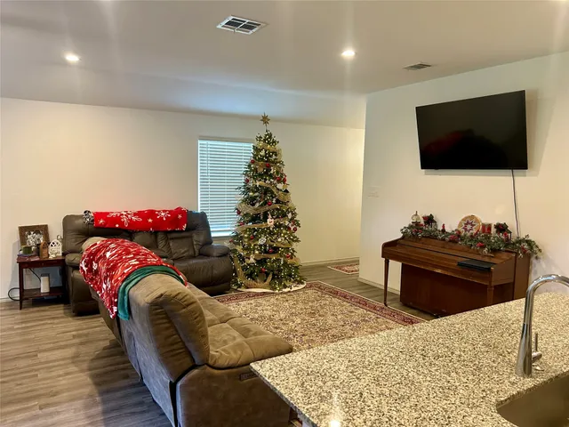 a living room with furniture a flat screen tv and a potted plant