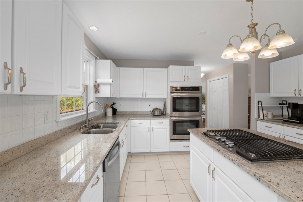 203 Richie Road Attleboro, MA 02703 - Photo 11 of 42 a kitchen with a stove cabinets and a refrigerator
