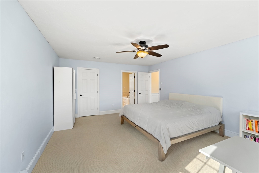 203 Richie Road Attleboro, MA 02703 - Photo 25 of 42 a spacious bedroom with a bed and a chandelier