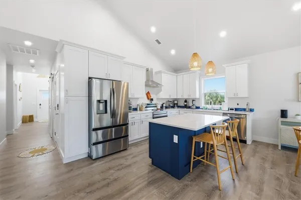 a kitchen with a sink dishwasher stove and white cabinets