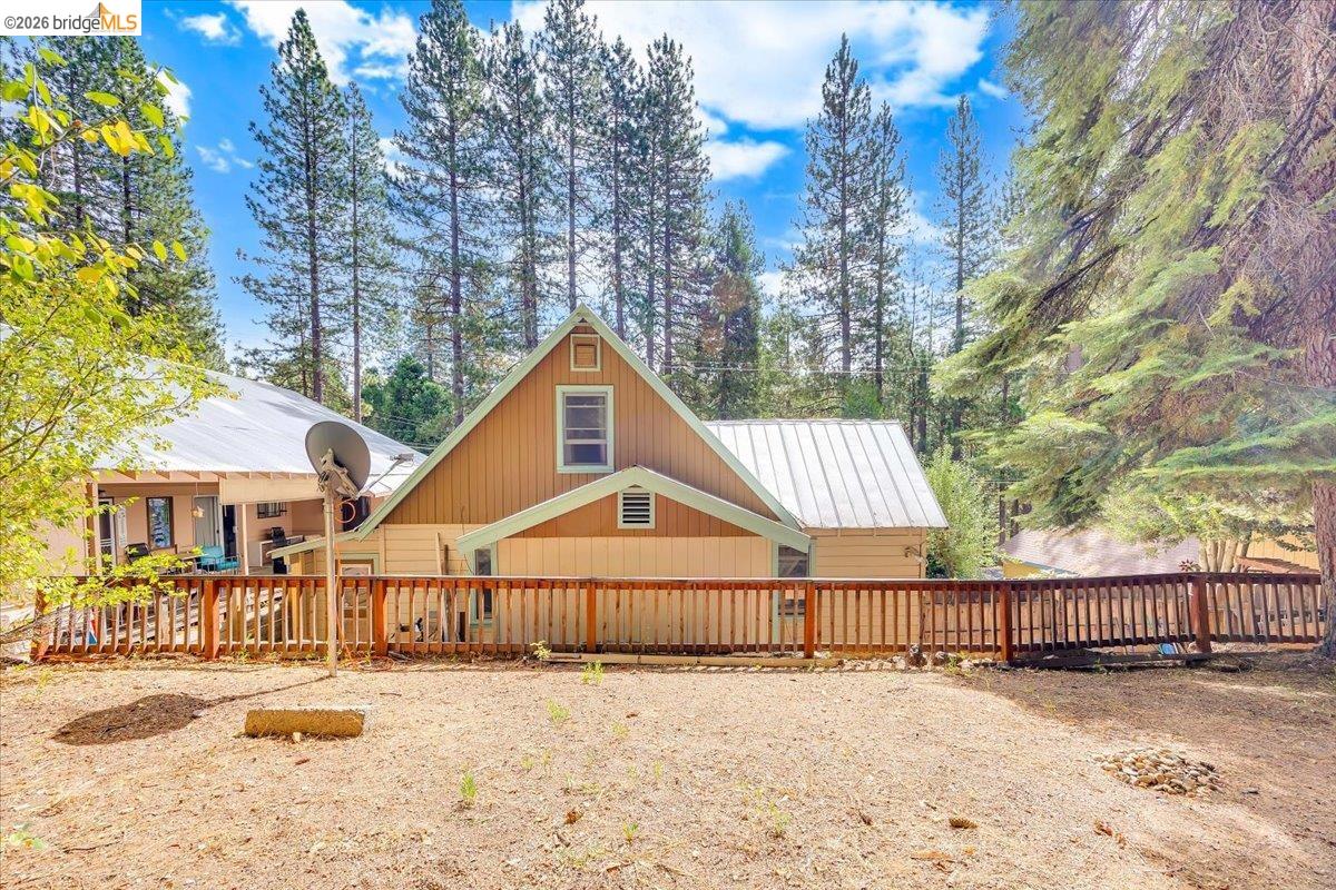 26144 Long Barn Road Long Barn, CA 95335 - Photo 39 of 42 Gable roofline, metal roofing, wood siding, wood deck, and surrounding mature trees