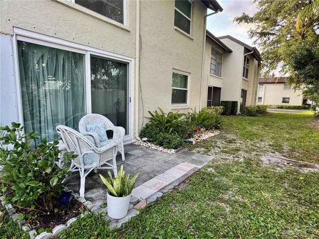 a view of a chair and table in backyard of the house