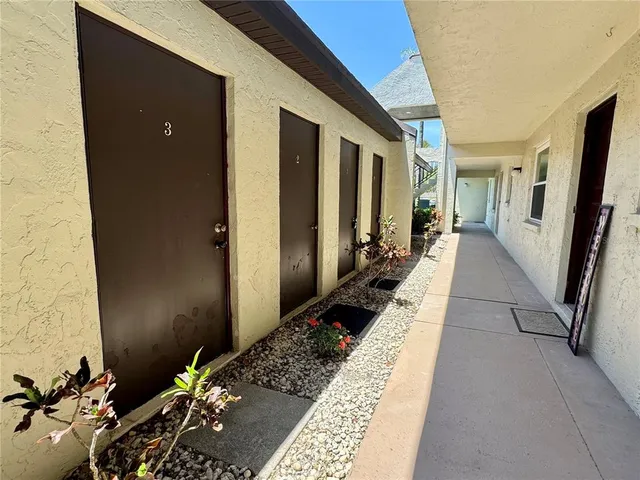 a view of a porch with chairs and potted plants
