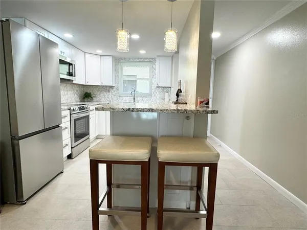a kitchen with kitchen island cabinets and chair