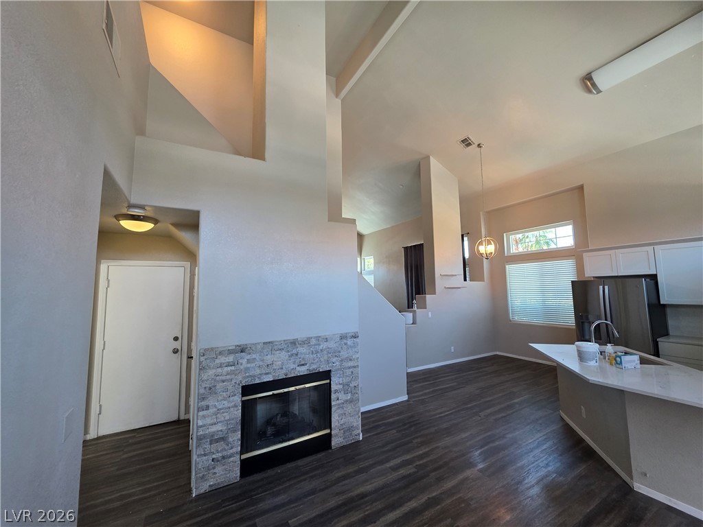2275 Ramsgate Drive Henderson, NV 89074 - Photo 24 of 84 An open concept living area boasts a fireplace and soaring ceilings, creating a light-filled ambiance.