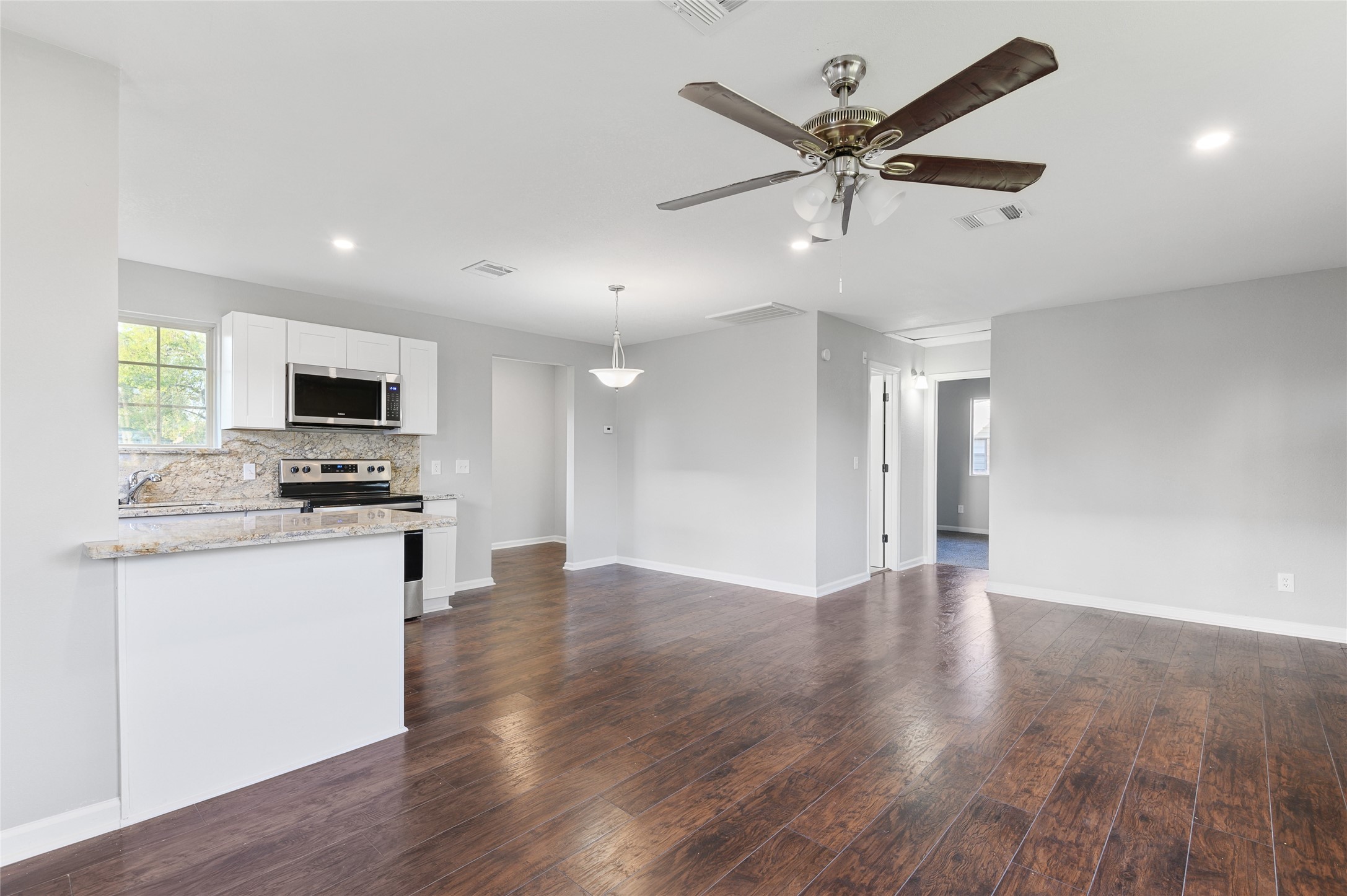 986 Dewalt Street Houston, TX 77088 - Photo 13 of 18 a view of an empty room with kitchen appliances and a ceiling fan