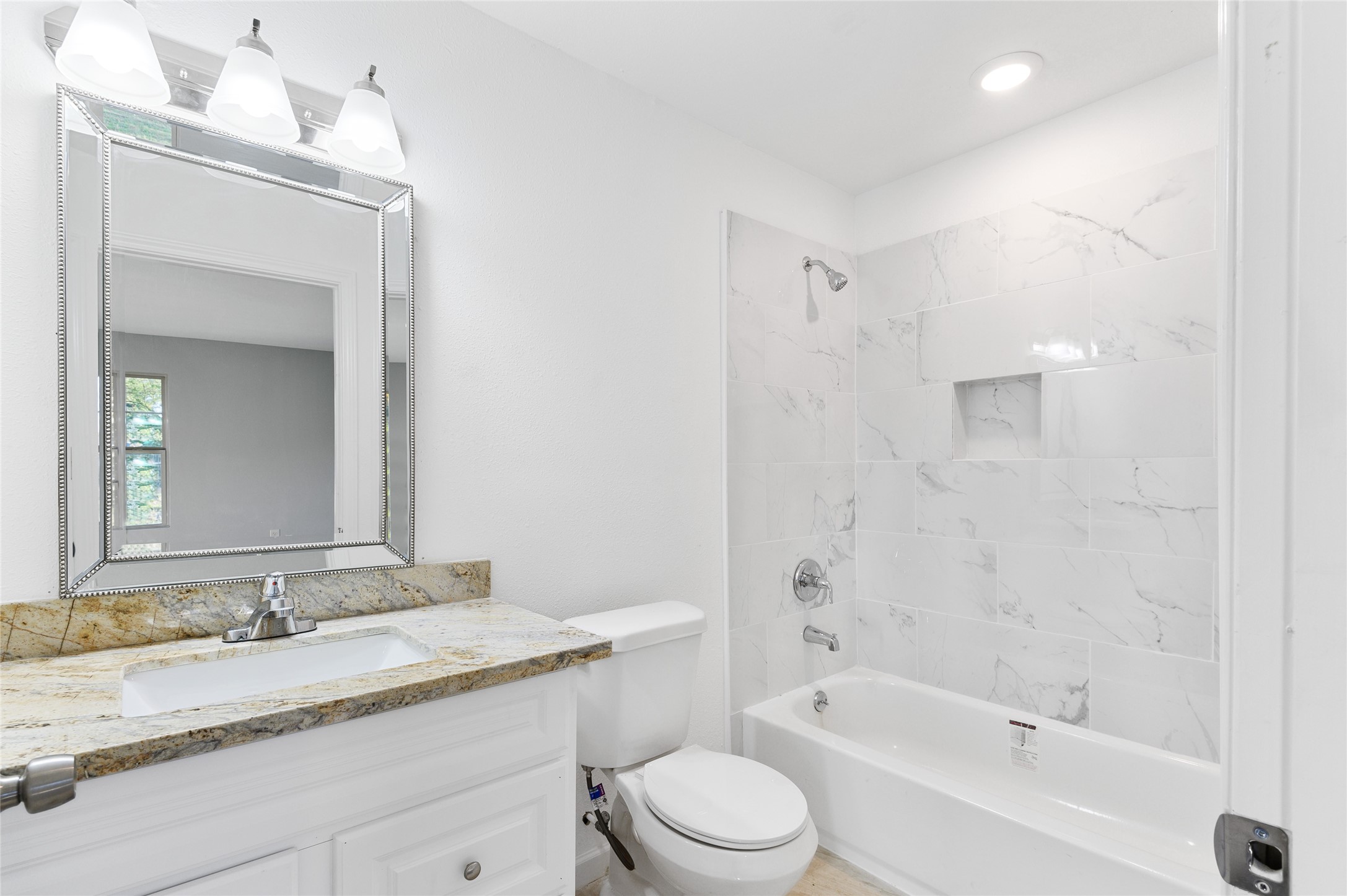 986 Dewalt Street Houston, TX 77088 - Photo 6 of 18 a bathroom with a granite countertop sink a toilet and bathtub