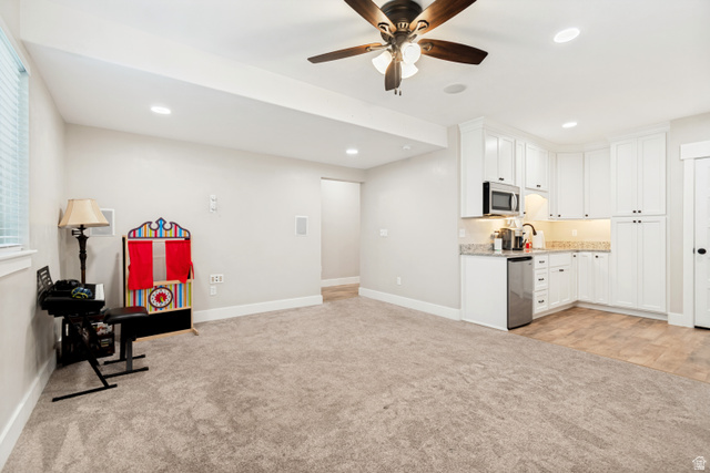 332 South 500 West Payson, UT 84651 - Photo 30 of 50 Spacious carpeted tv room featuring a white cabinetry kitchenette with a stainless steel microwave, compact refrigerator, and granite countertop