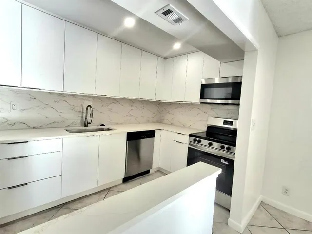 a kitchen with white cabinets and white appliances