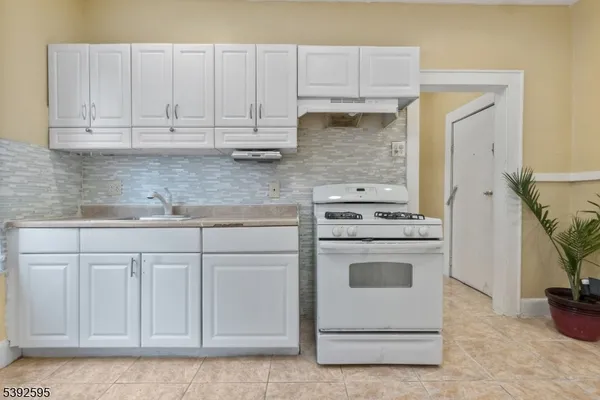 a kitchen with white cabinets and white appliances