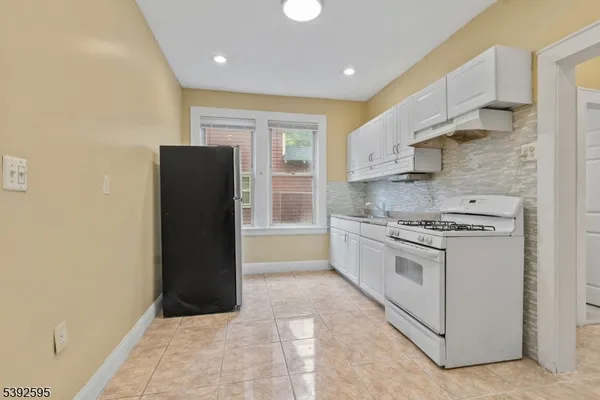 a kitchen with stainless steel appliances granite countertop a refrigerator and a stove
