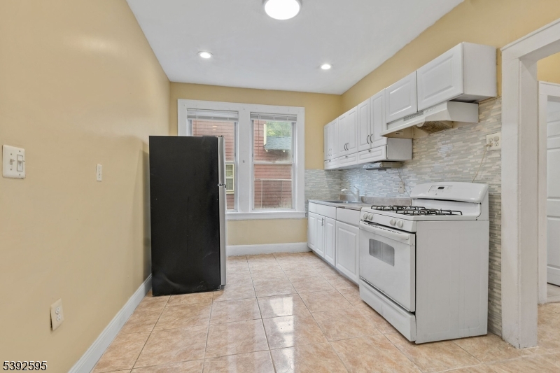 213 Maple Avenue Irvington, NJ 07111 - Photo 6 of 17 a kitchen with stainless steel appliances granite countertop a refrigerator and a stove