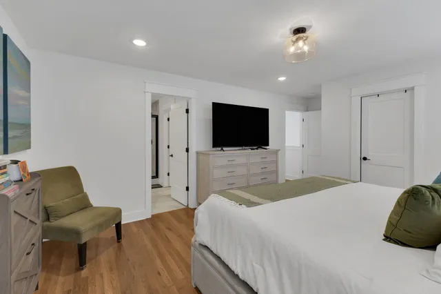 a bedroom with a bed tv and chair