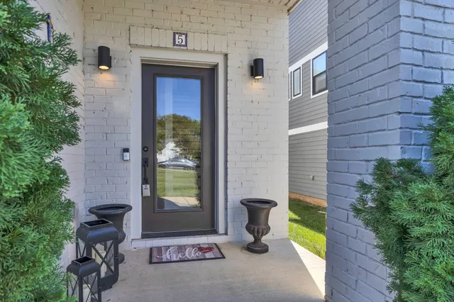 a brick house with a potted plant in front of it