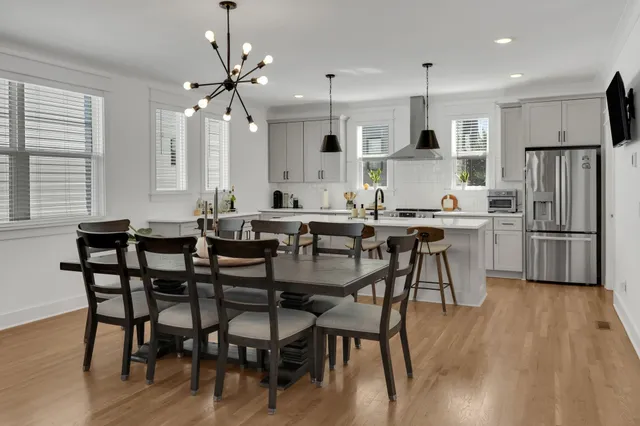 a kitchen with stainless steel appliances kitchen island granite countertop a dining table chairs and granite counter tops