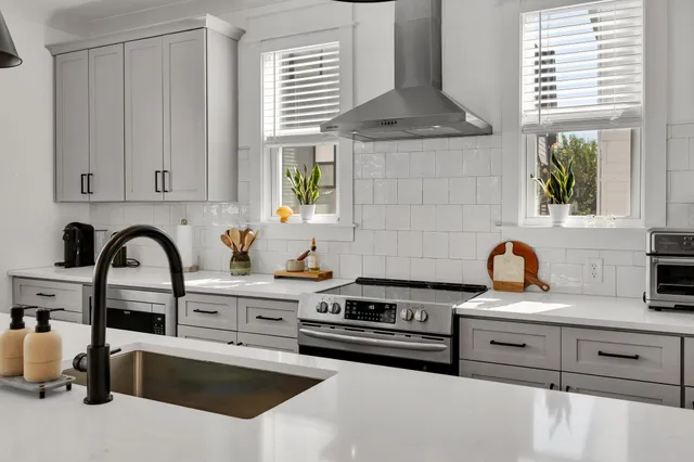 a kitchen with granite countertop a sink stainless steel appliances and window