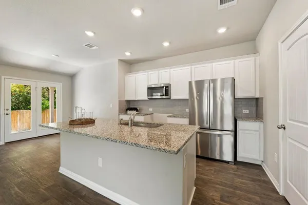 a kitchen with stainless steel appliances granite countertop a refrigerator a sink a stove a microwave and island