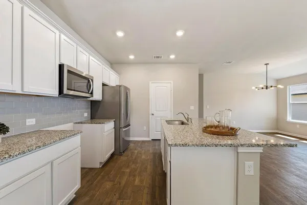a kitchen with sink refrigerator and microwave