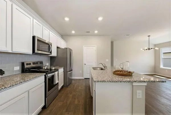 a kitchen with stainless steel appliances granite countertop a sink stove and refrigerator