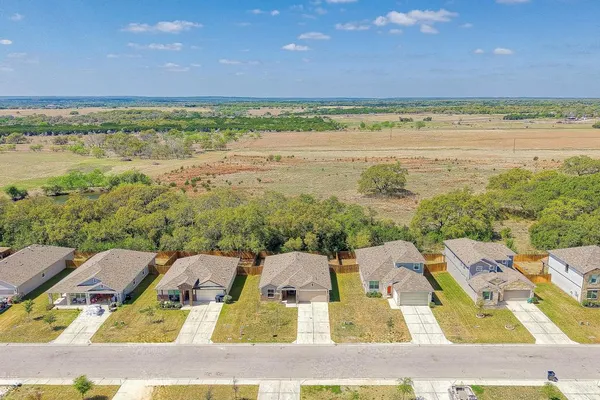 an aerial view of residential houses with outdoor space and lake view