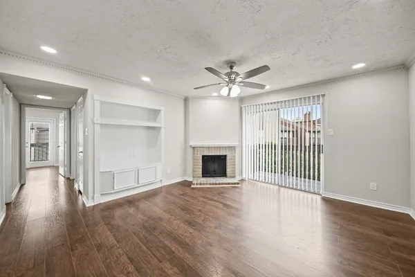a view of a livingroom with wooden floor and a fireplace