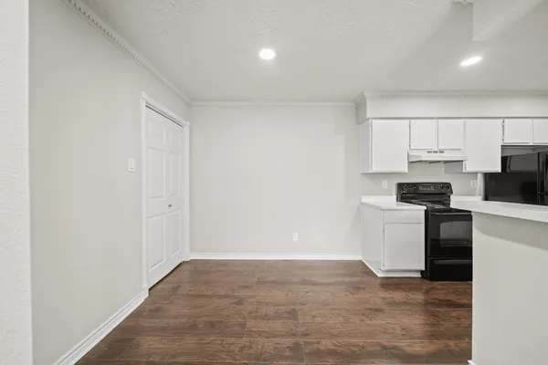 a kitchen with a refrigerator and white cabinets