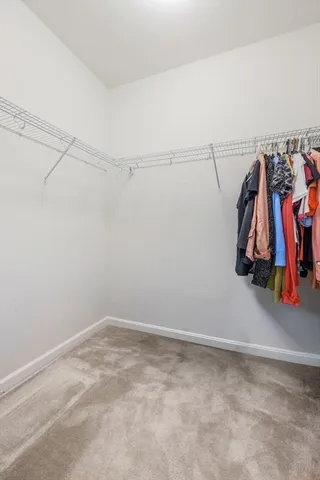 a view of walk in closet with clothes