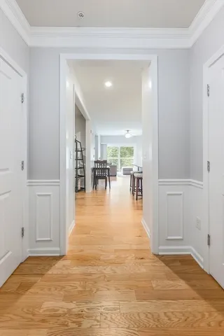 a view of a hallway with wooden floor and dining room