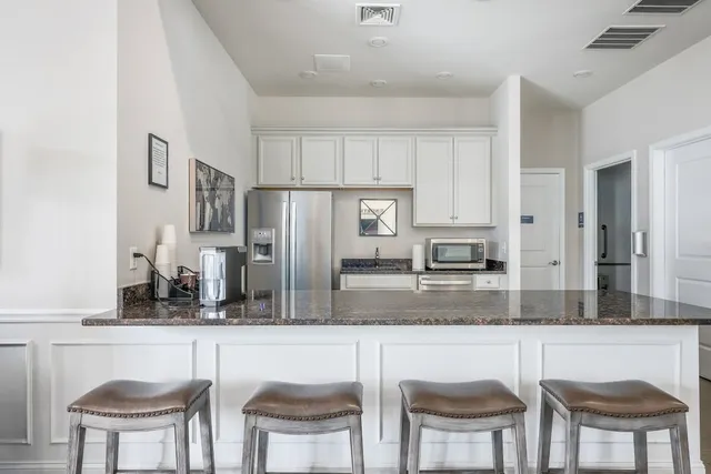 a kitchen with stainless steel appliances granite countertop a table and chairs