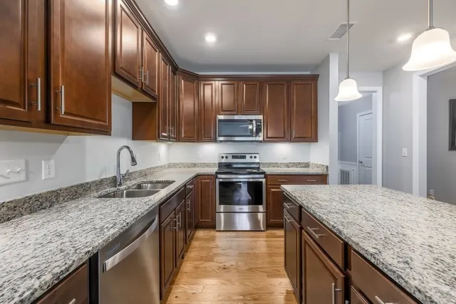 a kitchen with granite countertop stainless steel appliances and wooden cabinets