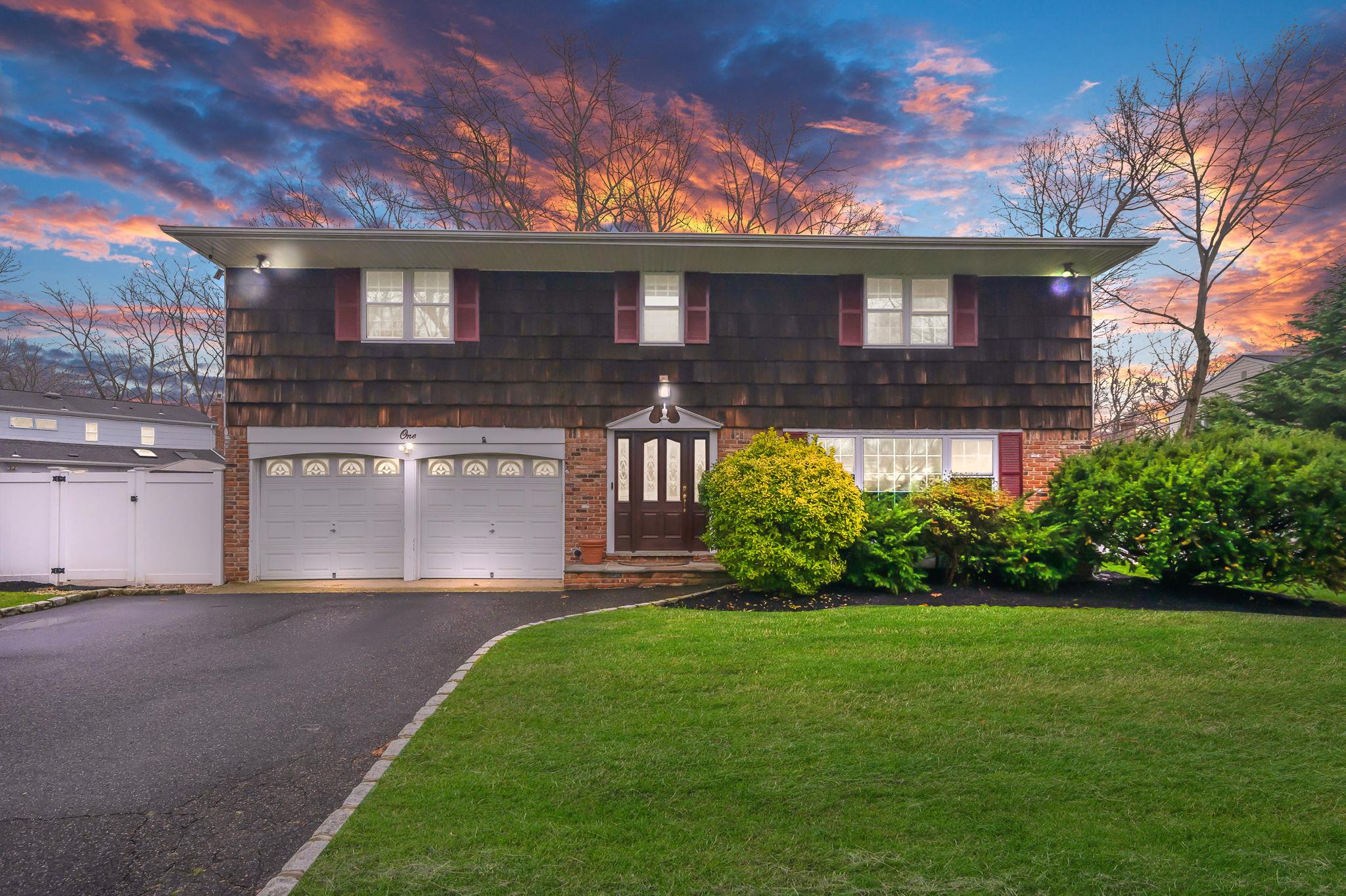 a front view of a house with a garden and plants