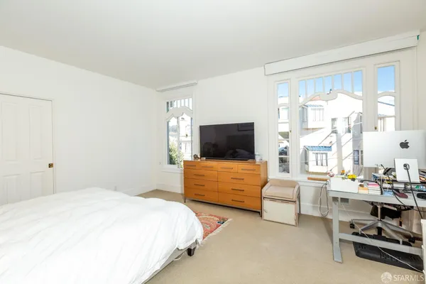a bedroom with a bed and a flat screen tv