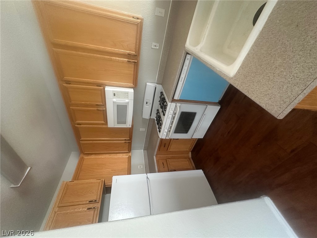 4730 East Craig Road, Unit 1073 Las Vegas, NV 89115 - Photo 4 of 18 Warm wood cabinetry pairs with rich wood flooring in this functional kitchen space.