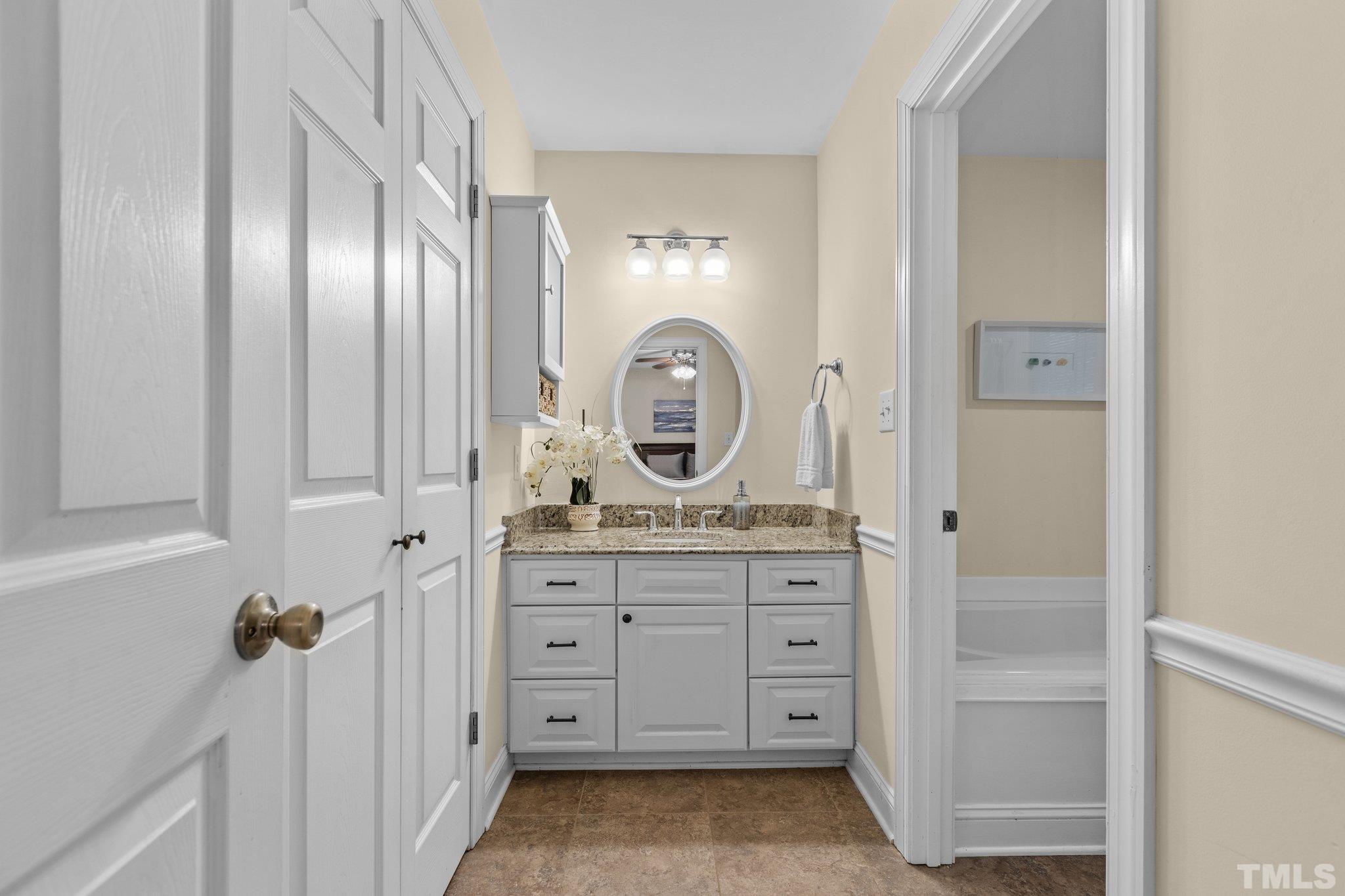 108 Rhododendron Court Chapel Hill, NC 27517 - Photo 20 of 38 a bathroom with a granite countertop sink a mirror and a vanity