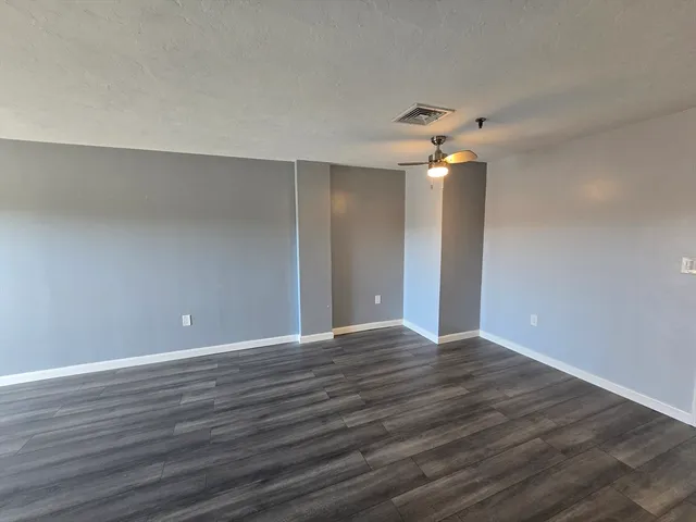 a view of an empty room with wooden floor