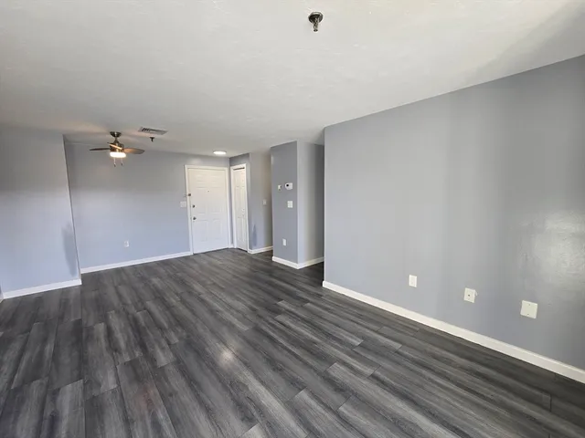 a view of an empty room with wooden floor